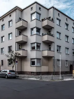 Bílá betonová budova vedle zeleného stromu za dne
