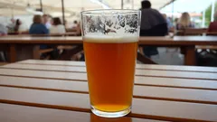 Půllitr piva na dřevěném stole v letní zahrádce restaurace
