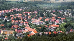Město v horách s domy mezi zelenými stromy a kopci